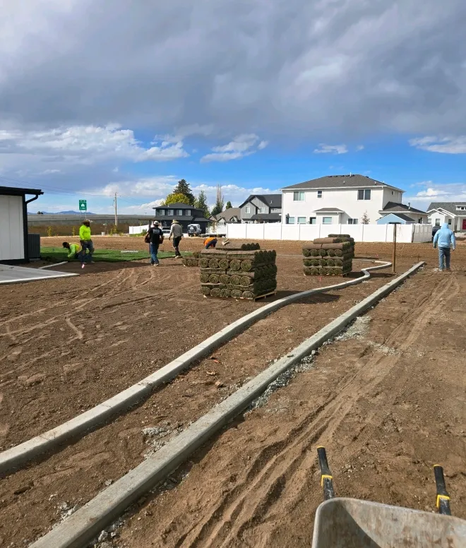 Crew laying sod beside new landscape curbing in a Northern Utah yard