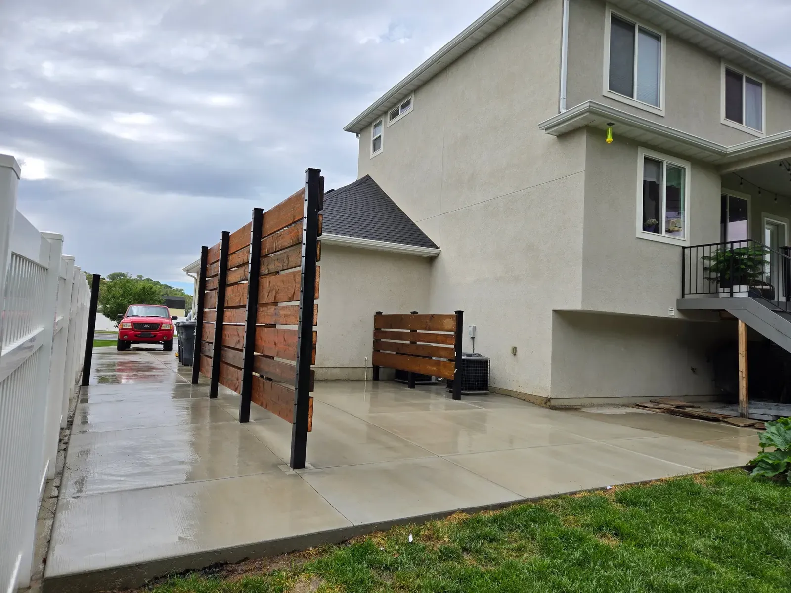 Finished concrete patio and walkway with a horizontal wood privacy fence in South Weber