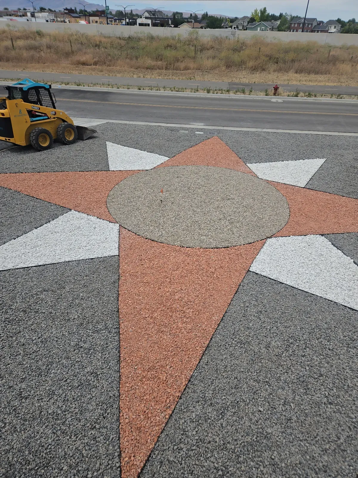 Eight-point gravel star in tan, rust, and white inside a circular Syracuse curb