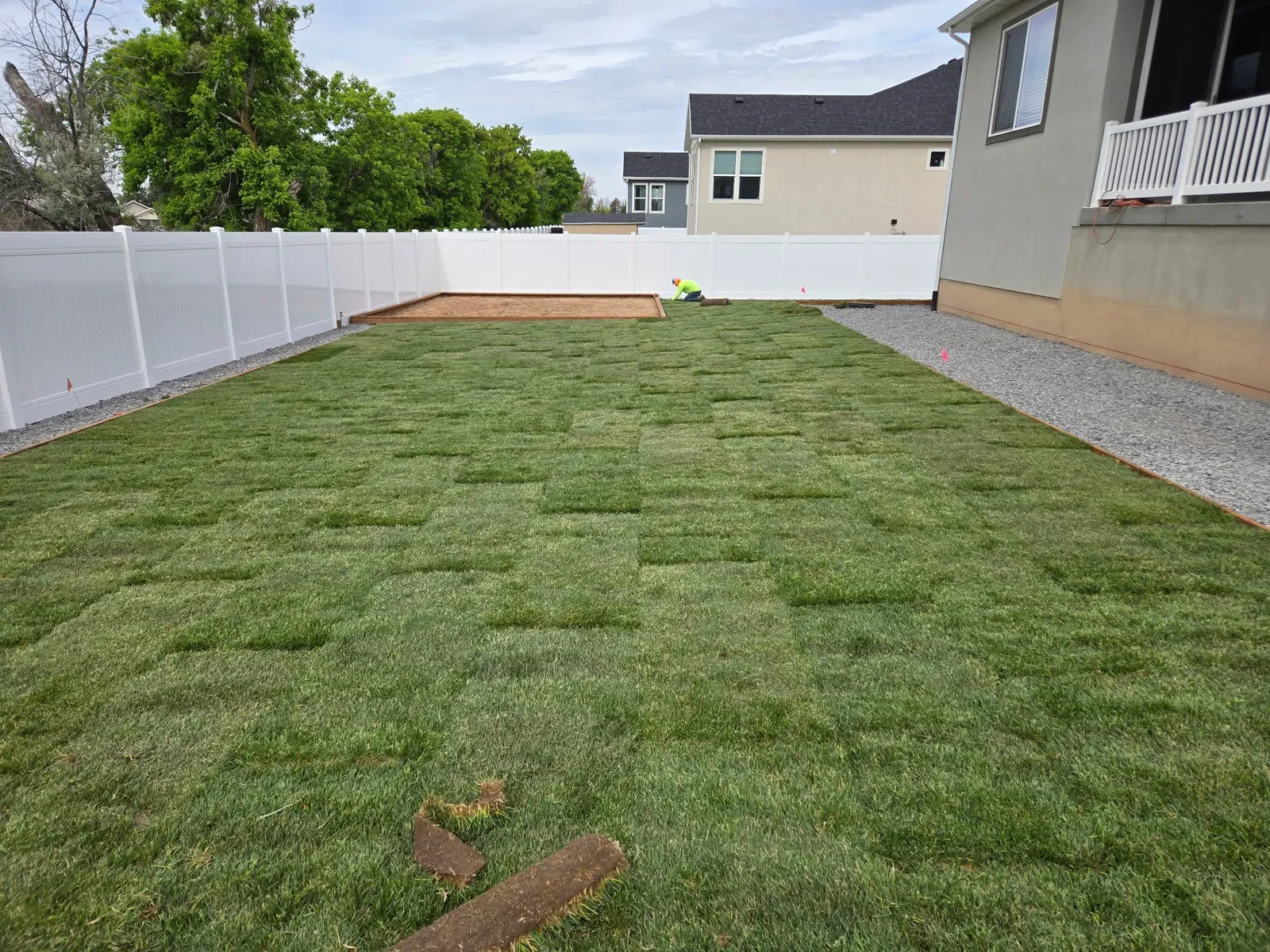 Newly laid sod in a Harrisville backyard next to a gravel border
