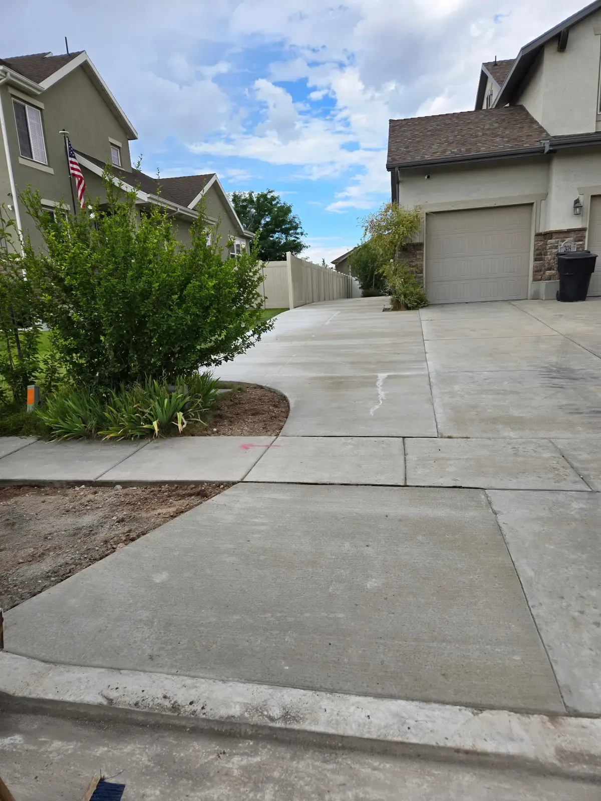 Finished concrete driveway and sidewalk with clean control joints in Roy